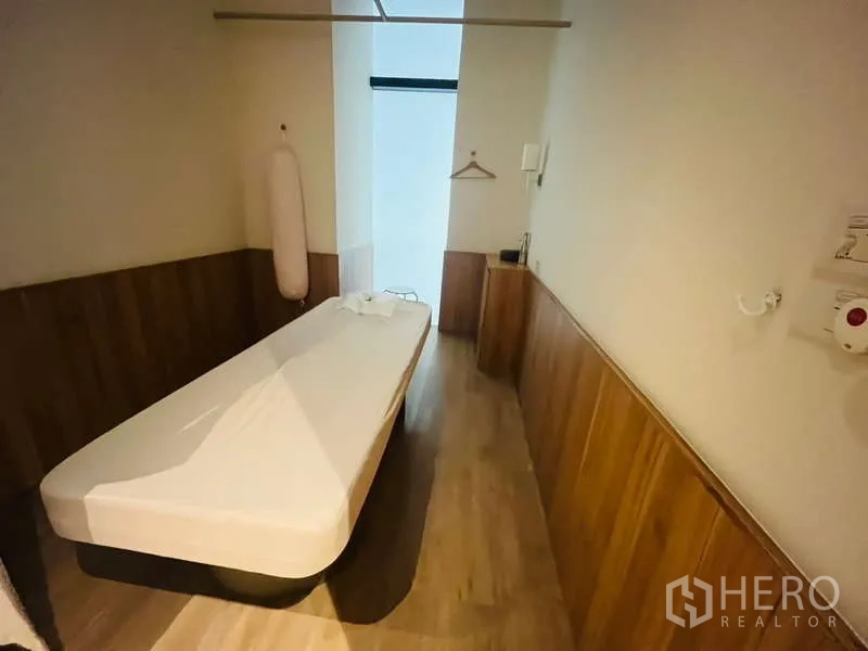 Retail Space for rent - Private treatment room with wood wainscoting and a massage bed inside the unit.