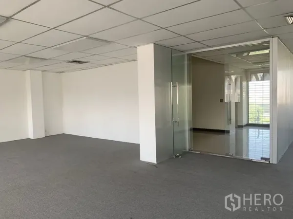 Office Space for rent in Bang Kapi, Bangkok - Open office area with carpet tiles and a glass-partitioned meeting room with double doors and abundant daylight.