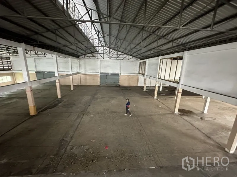 Factory for rent or sale in Khlong Luang, Pathum Thani - Wide open manufacturing area viewed from mezzanine under a metal roof.