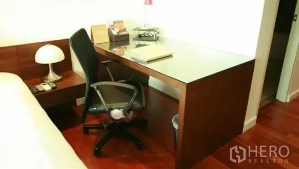 公寓 出租或出售在Watthana, Bangkok - 卧室内的内置书桌与办公椅，木地板质感出众。