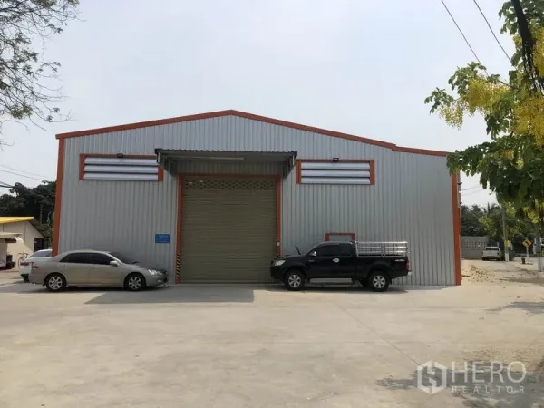 คลังสินค้า ให้เช่าในBang Yai, Nonthaburi - ด้านหน้าตัวอาคารมีประตูม้วนขนาดใหญ่ กันสาด และลานจอดรถกว้าง