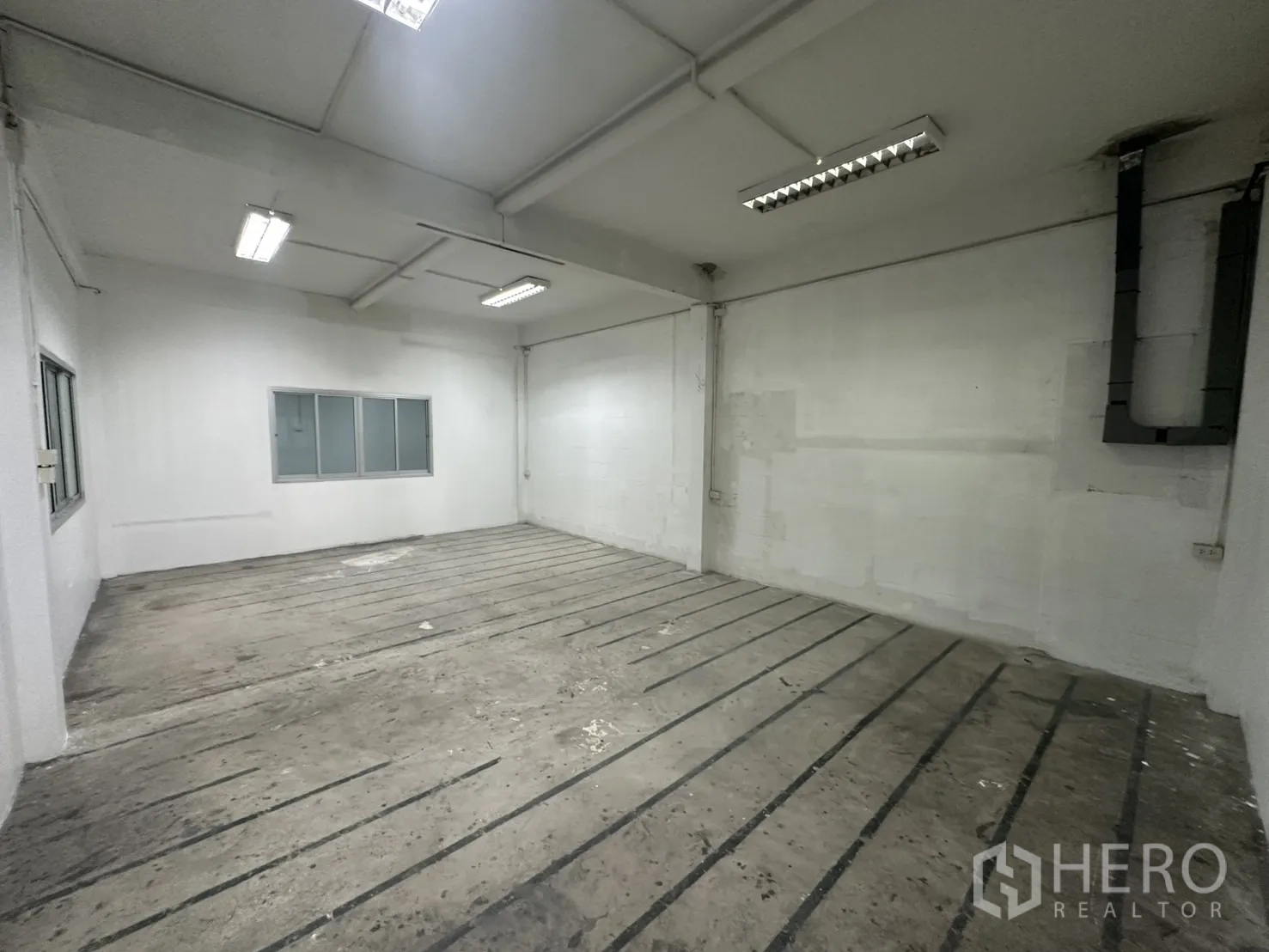 Warehouse for rent in Bang Na, Bangkok - Work bay with fluorescent lighting, wall conduit and ventilation.