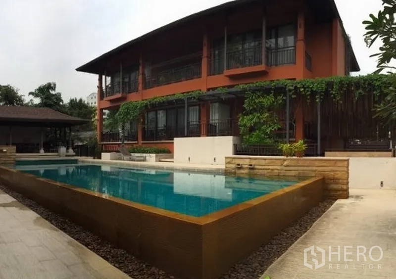 บ้าน ให้เช่าในKhlong Toei, Bangkok - อาคารวิลล่าโลว์ไรส์ท่ามกลางต้นไม้ พร้อมสระว่ายน้ำทรงสี่เหลี่ยมและดาดฟ้าริมสระ