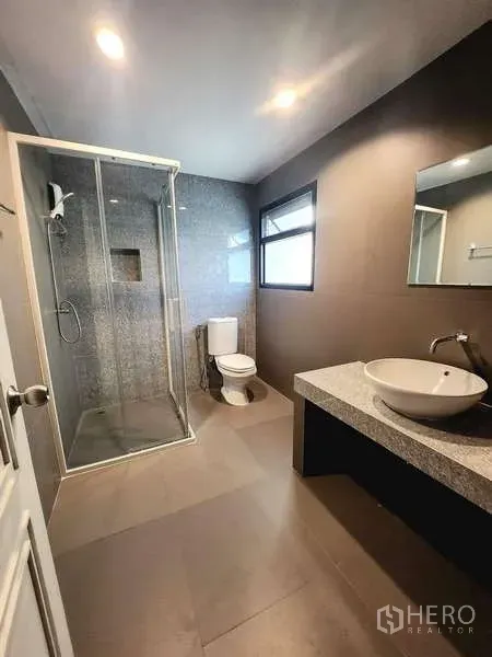 联排别墅 出租在Watthana, Bangkok - 现代浴室，玻璃淋浴间、台上盆与带窗采光。