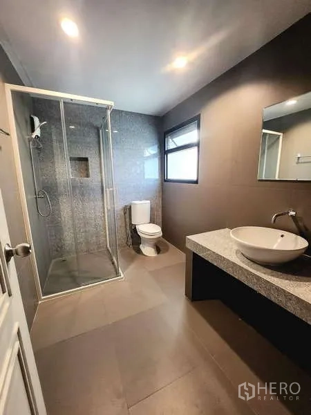 联排别墅 出租在Watthana, Bangkok - 现代浴室，玻璃淋浴间、台上盆与带窗采光。