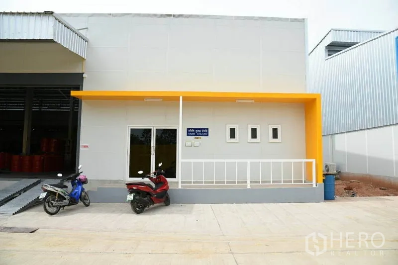 คลังสินค้า ให้เช่าในThung Khru, Bangkok - ด้านหน้าออฟฟิศมีชายคาสีเหลืองและประตูกระจกข้างทางขึ้นโหลดสินค้า
