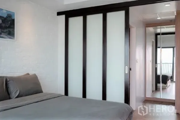 公寓 出租在Khlong Toei, Bangkok - 卧室配磨砂玻璃推拉衣柜门，走廊镜面通往阳台。