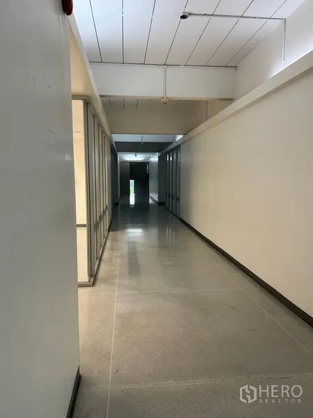 Office Space for rent in Mueang Samut Prakan, Samut Prakan - Long hallway with glass-walled offices and polished floors.