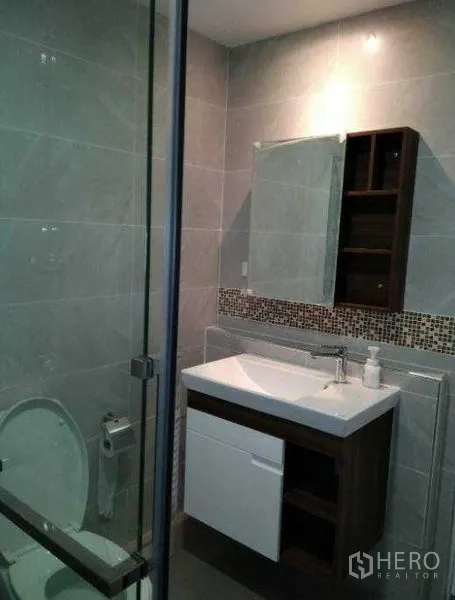 公寓 出租在Khlong Toei, Bangkok - 现代化浴室，玻璃淋浴间、洗手台与灰色瓷砖