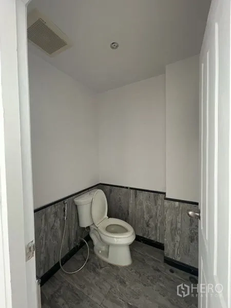 零售空间 出租 - 整洁卫生间，坐便器、喷枪与灰色墙面