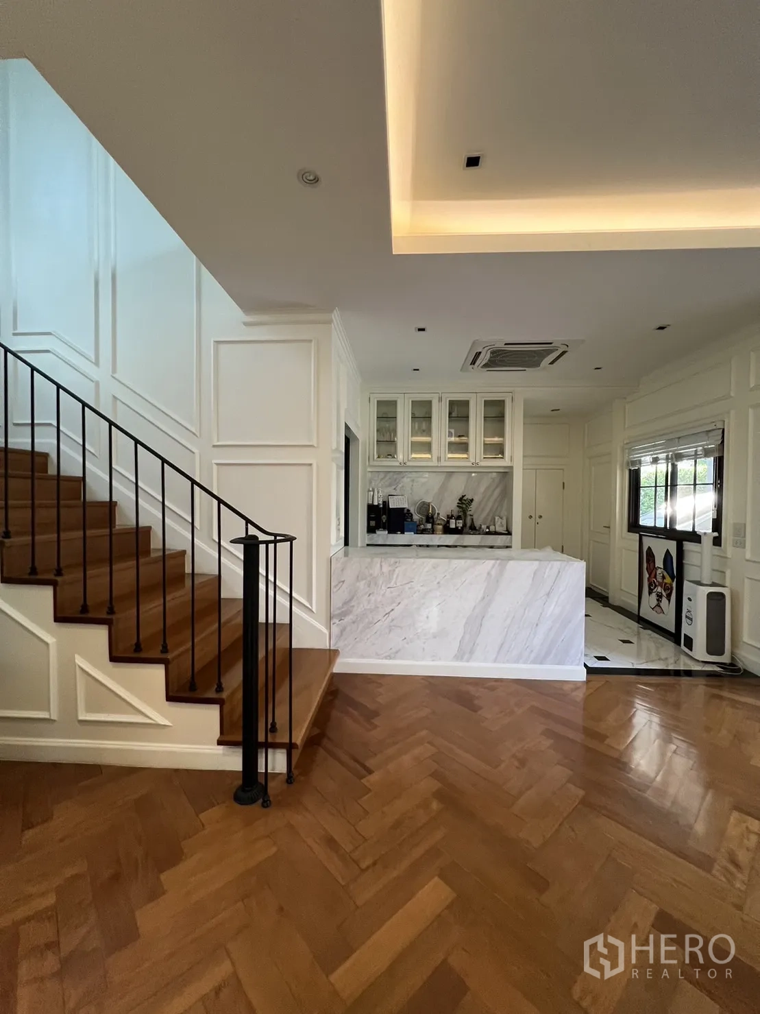 Detached House for rent in Suan Luang, Bangkok - Open-plan area showing wooden staircase and marble breakfast bar kitchen.