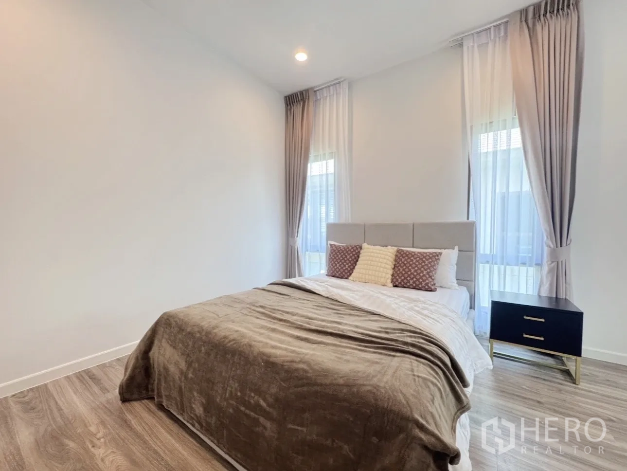 บ้าน ให้เช่าหรือขายในBang Kapi, Bangkok - ห้องนอนแขกมุมมองพร้อมโต๊ะข้างเตียงและผ้าม่านโปร่ง