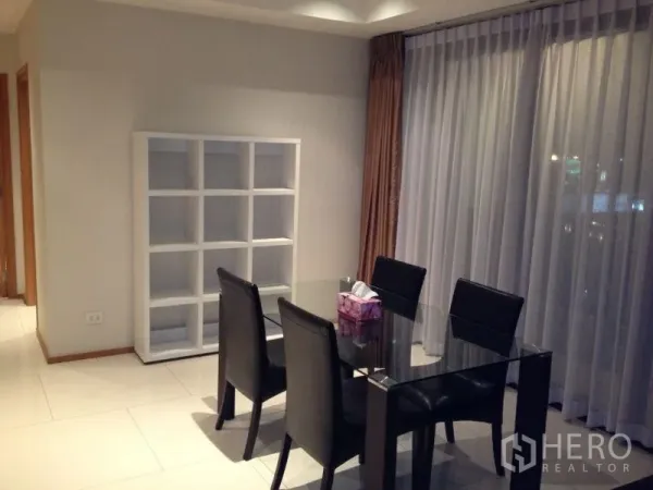 คอนโด ให้เช่าหรือขายในKhlong Toei, Bangkok - มุมรับประทานอาหาร โต๊ะกระจก เก้าอี้หนังสีดำ ผ้าม่านบานสูง และชั้นวางแบบช่องสี่เหลี่ยม