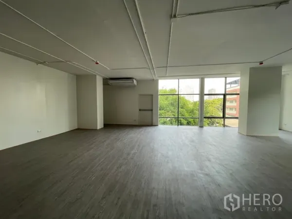 Office Space for rent in Bang Rak, Bangkok - Spacious workspace featuring a large glazed wall, vinyl floors and a central column.