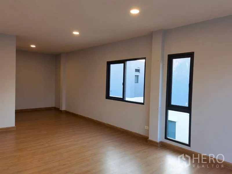 Detached House for rent in Bang Phli, Samut Prakan - Spacious upper floor room with wood floors and recessed lighting.