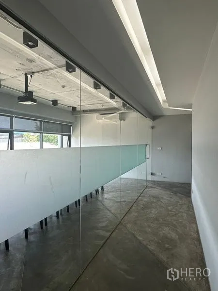 Home Office for rent or sale in Prawet, Bangkok - Glass-walled meeting room with ceiling track lights and projector.