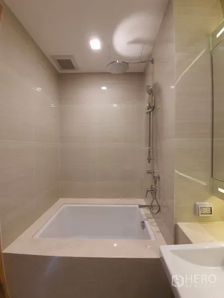 คอนโด ให้เช่าในWatthana, Bangkok - ห้องน้ำโมเดิร์นพร้อมอ่างอาบน้ำและฝักบัวเรนชาวเวอร์ ผนังกระเบื้องโทนเบจ