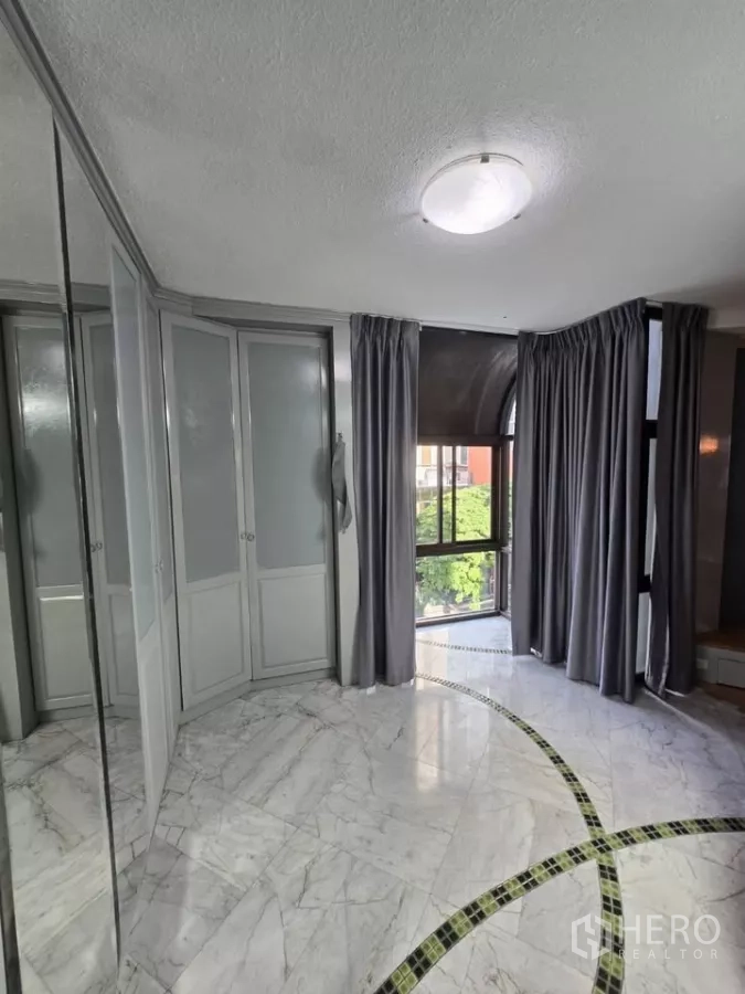 Condominium for rent in Pathum Wan, Bangkok - Bright dressing area with marble floor, built-in closets and curved window.