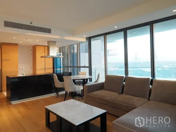 Condominium for rent in Yan Nawa, Bangkok - Spacious living room with L-shaped sofa, balcony access and full-height glazing.