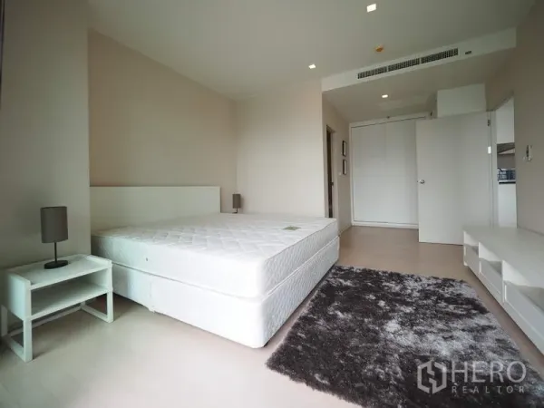 คอนโด ให้เช่าในWatthana, Bangkok - ห้องนอนกว้าง มีตู้เสื้อผ้าบิลท์อิน โต๊ะข้างเตียง และพรมโทนอุ่นในคอนโดสไตล์โมเดิร์น