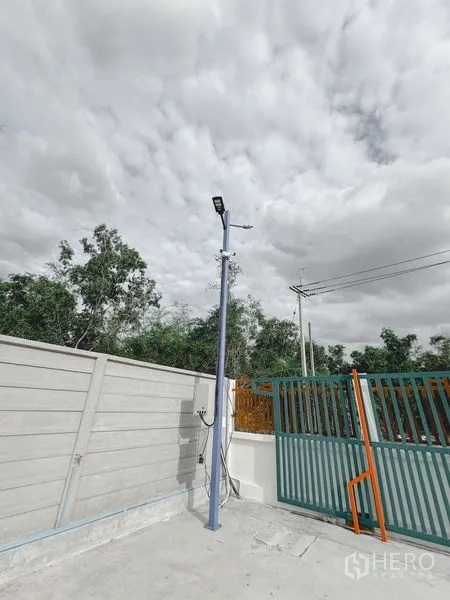 货栈 出租或出售在Khlong Luang, Pathum Thani - 入口近景，金属推拉门、庭院路灯与供电设施。