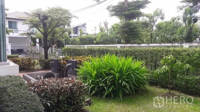 Detached House for rent in Saphan Sung, Bangkok - Private garden with trimmed hedges, shrubs, and trees inside a walled yard.