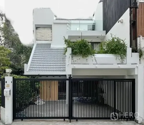 ทาวน์เฮาส์ ให้เช่าในKhlong Toei, Bangkok - หน้าบ้านทาวน์เฮ้าส์สีขาวสไตล์โมเดิร์น พร้อมประตูรั้วและที่จอดรถในร่ม