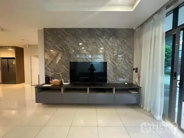 Detached House for rent in Bang Kapi, Bangkok - TV wall on a marble panel with floating console and sliding glass doors to the patio.