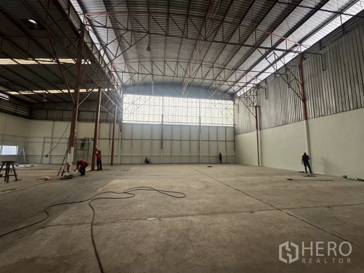 工厂 出租在Pak Kret, Nonthaburi - 宽阔作业区，山墙钢架屋顶与大面积透光窗，混凝土地面。