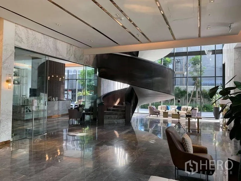 公寓 出售在Khlong Toei, Bangkok - 高端公寓大堂，挑高空间、玻璃幕墙与雕塑感旋转楼梯