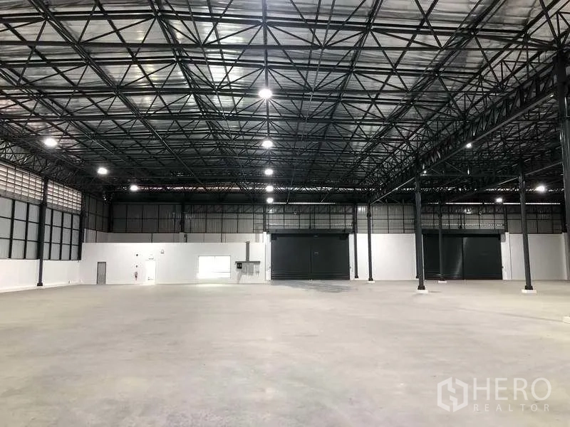 Factory for rent in Bang Sao Thong, Samut Prakan - Wide factory hall showing insulated roof, steel columns and smooth concrete slab.