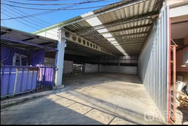 Warehouse for rent in Din Daeng, Bangkok - Covered warehouse entrance with metal roof, open bay and concrete floor.