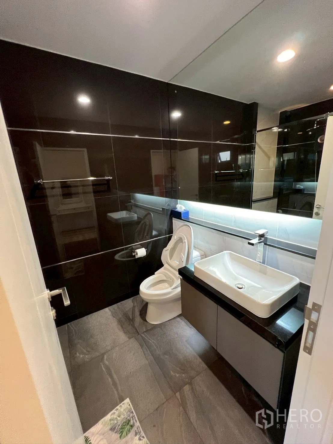 独栋房屋 for rent in Bang Kapi, Bangkok - 现代浴室，亮黑瓷砖、大镜面、台盆和坐便器。
