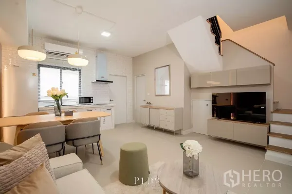 Townhouse for rent in Bang Phli, Samut Prakan - Open‑plan lounge with kitchen, dining bar, staircase and built‑in TV cabinet