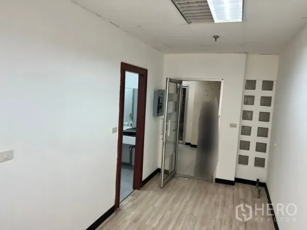 办公空间 出租在Pathum Wan, Bangkok - 小走廊，木纹地板，玻璃入户门，并可通往卫生间。