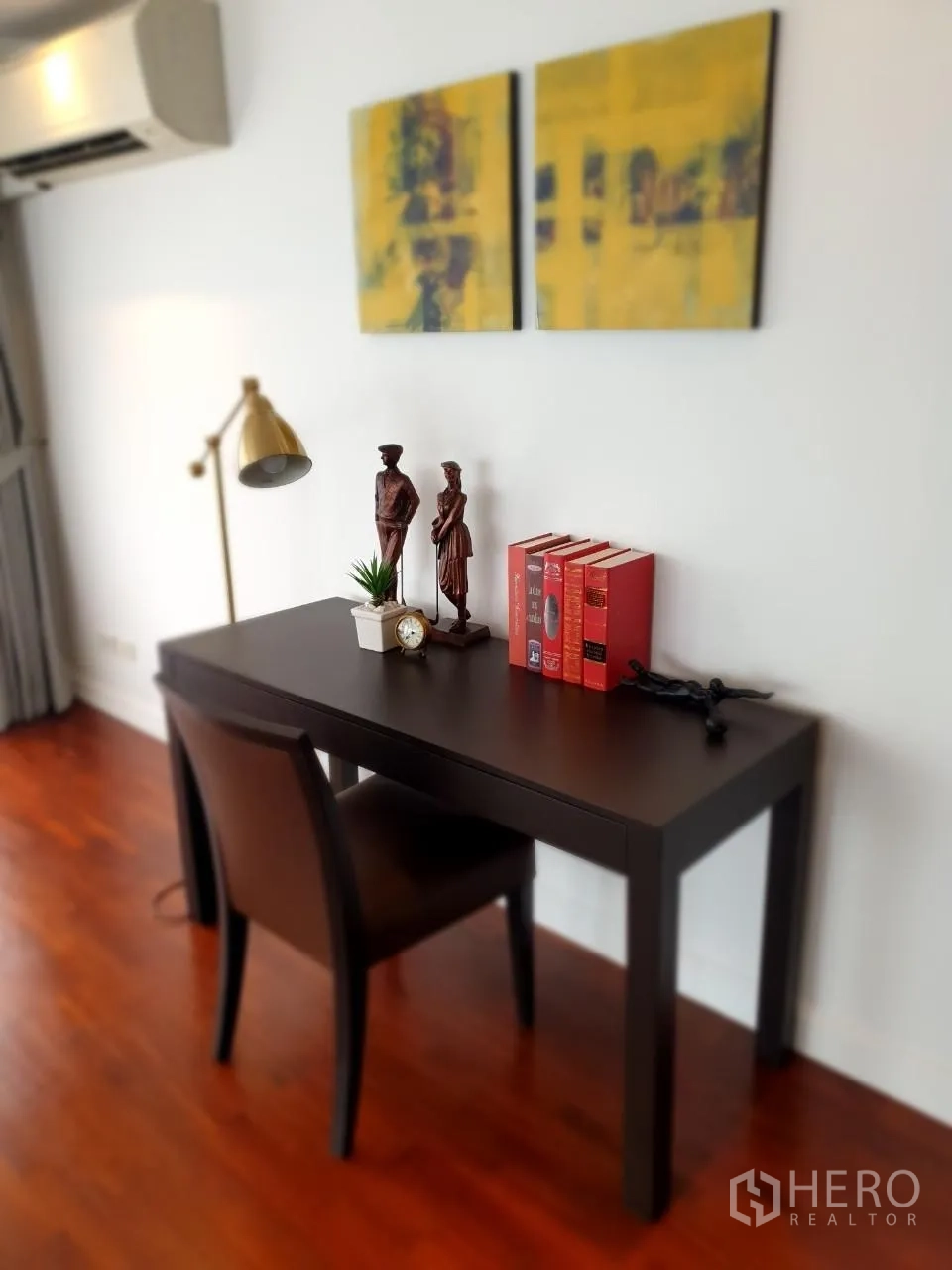 Apartment for rent in Bang Rak, Bangkok - Home office corner with dark wood desk, chair and brass reading lamp.