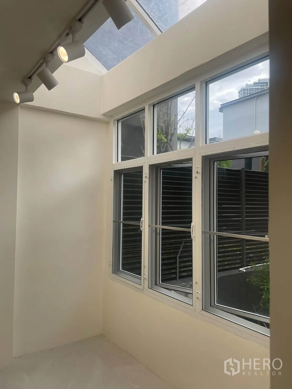 ทาวน์เฮาส์ for rent in Huai Khwang, Bangkok - มุมห้องรับแสงธรรมชาติด้วยสกายไลท์ ไฟรางสปอต และหน้าต่างกรอบขาว.