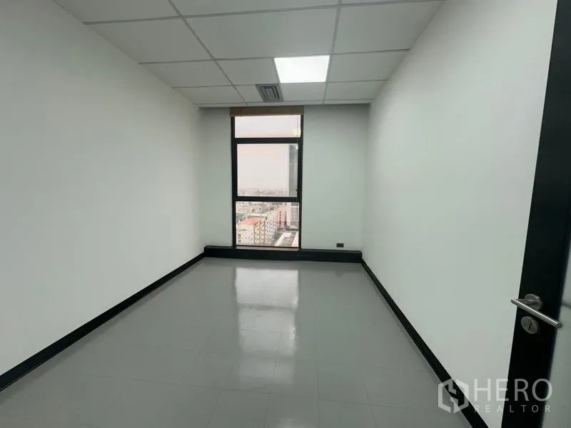 Office Space for rent - Compact office room with a single tall window and urban view.