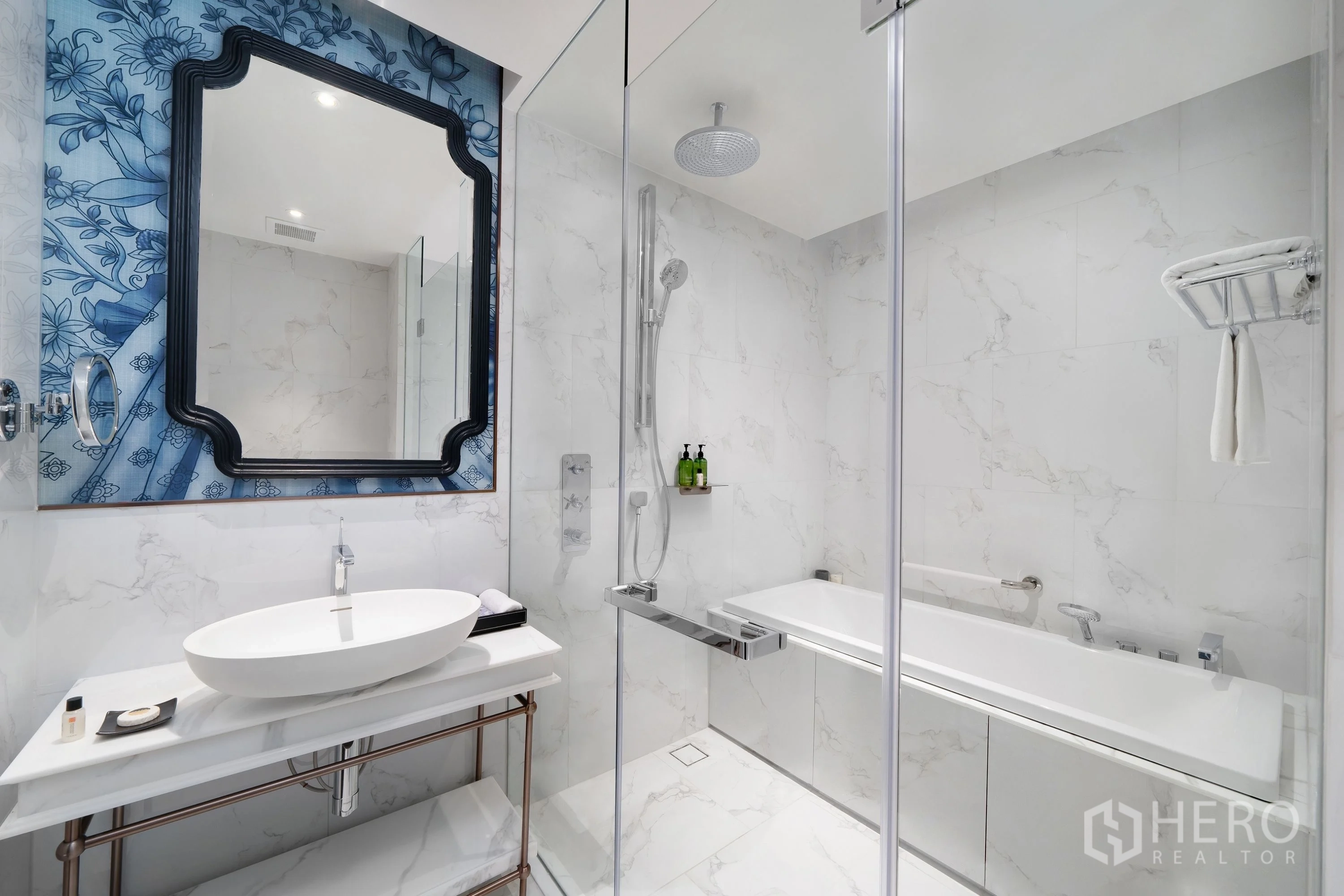 Condominium for rent in Khlong Toei, Bangkok - Modern bathroom with marble walls, vessel sink, glass shower, and bathtub.