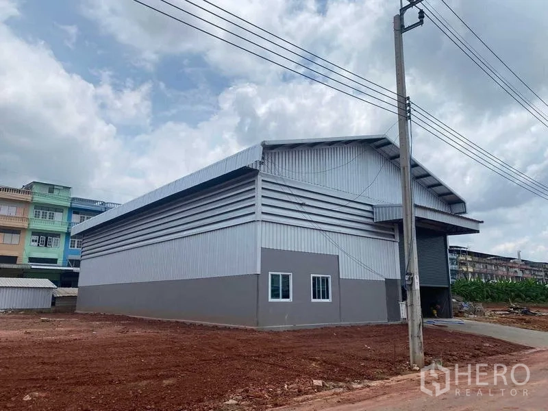 คลังสินค้า ให้เช่าในBang Bon, Bangkok - ภายนอกโกดังโครงเหล็กกรุเมทัลชีท หลังคาทรงจั่ว พร้อมประตูม้วนและลานด้านหน้า