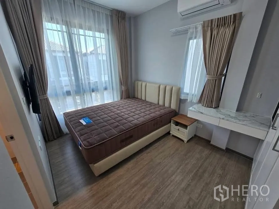 Semi-detached House for rent in Bang Phli, Samut Prakan - Bright bedroom with upholstered bed, sheer curtains, wall-mounted TV, and air conditioner.