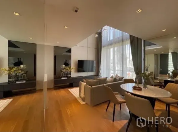 คอนโด ให้เช่าในKhlong Toei, Bangkok - มุมทานอาหารและโซฟาพร้อมผนังกระจกเงา พื้นไม้ และผ้าม่านสูง