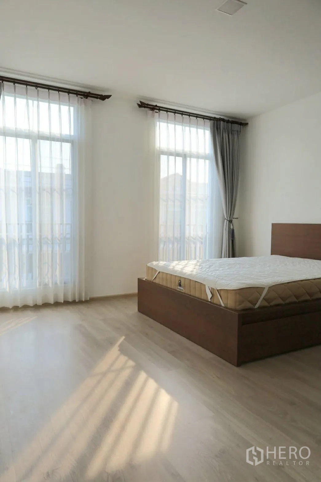 联排别墅 for rent in Prawet, Bangkok - 转角卧室，落地大窗与纱帘，空间宽敞明亮。