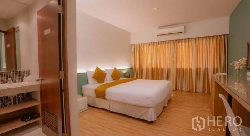 零售空间 出售在Phra Nakhon, Bangkok - 带卫浴入口的卧室，木地板与暖色灯光。