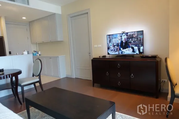 Condominium for sale in Pathum Wan, Bangkok - Bright living area with TV console, built-in cabinets, and warm wood floors.