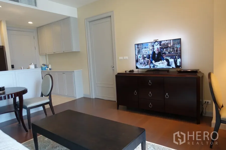 คอนโด ขายในPathum Wan, Bangkok - พื้นที่นั่งเล่นสว่างพร้อมตู้บิลต์อิน ทีวีคอนโซล และพื้นไม้โทนอุ่น