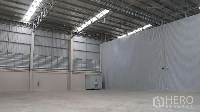 Warehouse for rent in Sam Phran, Nakhon Pathom - Open warehouse corner showing ventilation louvers and an internal restroom unit.