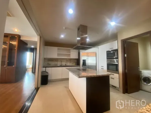 公寓 出租在Sathon, Bangkok - 现代厨房，石材岛台，不锈钢家电，旁有洗衣区。