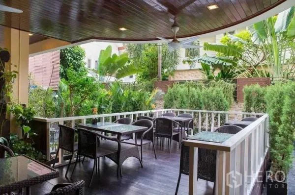 พื้นที่ขายปลีก ให้เช่าในKhlong Toei, Bangkok - ระเบียงกลางแจ้งมีโต๊ะกระจก เก้าอี้หวาย และสวนเขตร้อนร่มรื่น