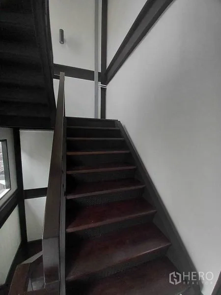 零售空间 出租在Khlong Toei, Bangkok - 楼梯平台，金属栏杆、壁灯、白墙与深色踏步